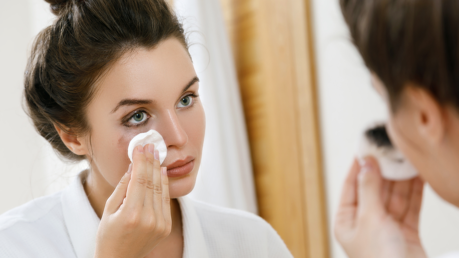 a woman removes her waterproof eyeliner