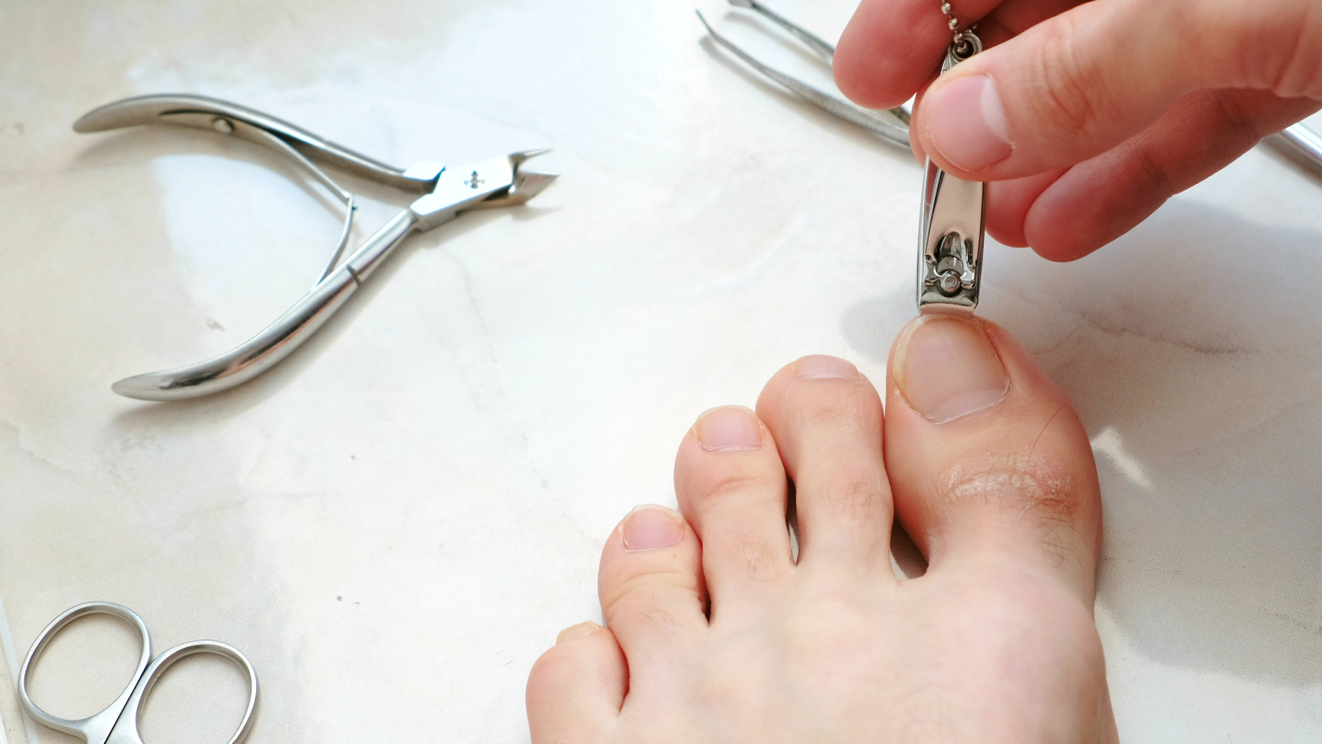 man cutting toenails with clipper