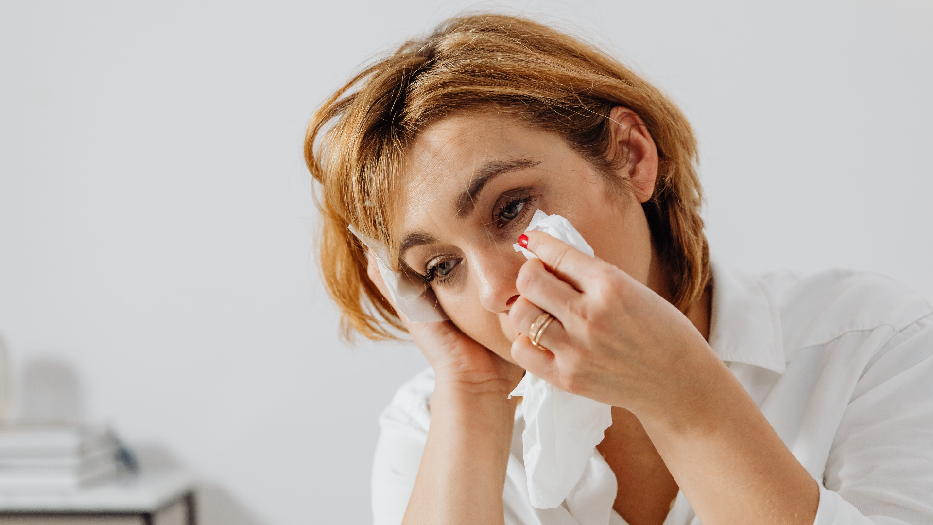 woman wiping her tears with a tissue