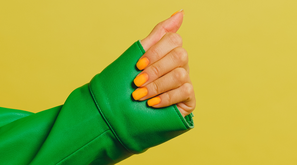 womans hand with yellow nail polish